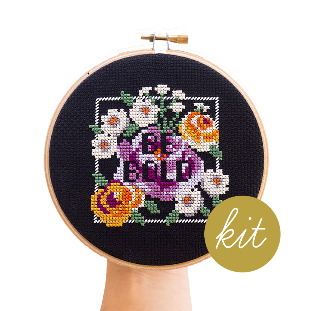 white, orange and purple flowers with green leaves cross stitch kit on black aida cloth, be bold in negative space lettering, DIY cross stitch kit