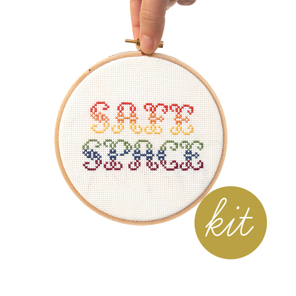 gradient rainbow playful font reading Safe Space, DIY cross stitch kit